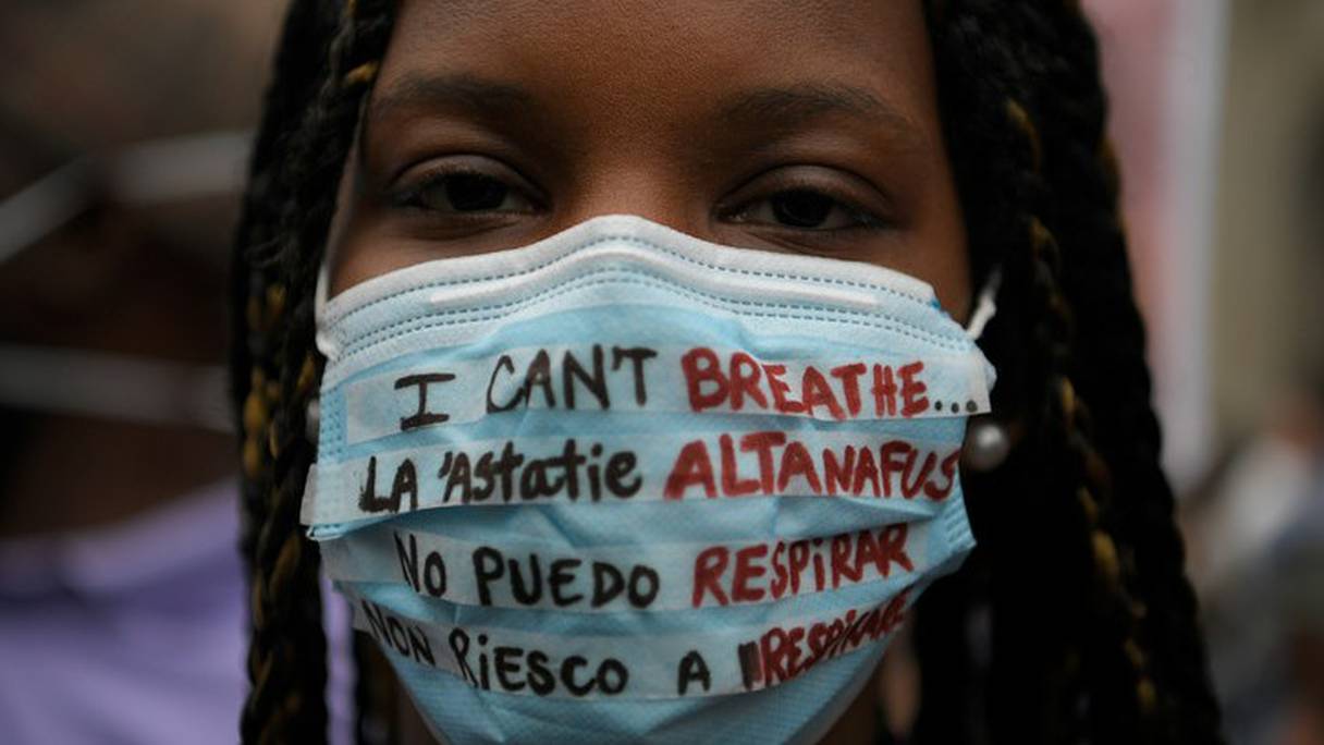 Une manifestante à Barcelone, le 7 juin 2020, dénonce le racisme en plusieurs langues sur son masque sanitaire. 
