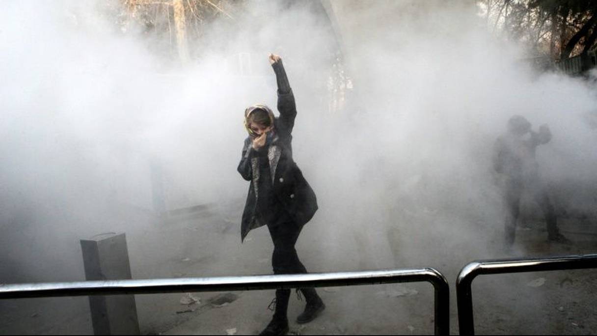 Une Iranienne lève le poing dans la fumée des gaz lacrymogènes lors d'une manifestation à Téhéran, le 30 décembre 2017.

