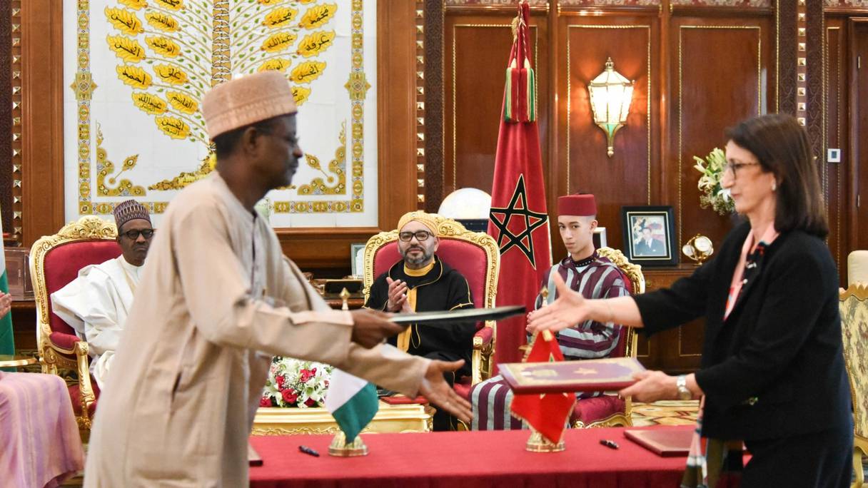 Cérémonie de signature, devant le président nigérian Muhammadu Buhari et le roi Mohammed VI, de la déclaration conjointe entre le Royaume et le Nigéria sur le gazoduc régional, par Amina Benkhadra et Farouk Garba Said, le 10 mai 2018 à Rabat. 
