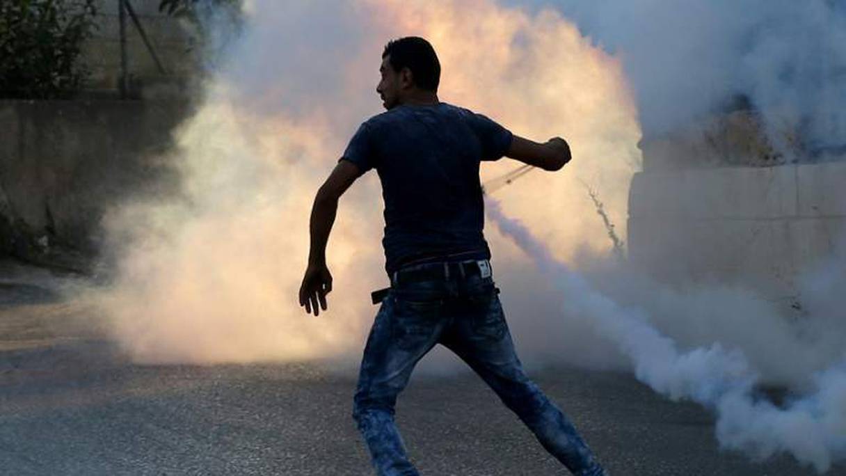 Un manifestant palestinien utilise un lance-pierres face aux forces antiémeutes israéliennes, le 31 juillet 2015 près d'un camp de réfugiés, en Cisjordanie occupée.
