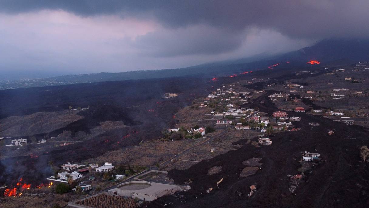 Cette photo aérienne montre une coulée de lave et des maisons recouvertes de lave suite à l'éruption du volcan Cumbre Vieja, à Las Norias, sur l'île canarienne de La Palma, le 13 décembre 2021. Le volcan Cumbre Vieja est en éruption depuis le 19 septembre 2021.

