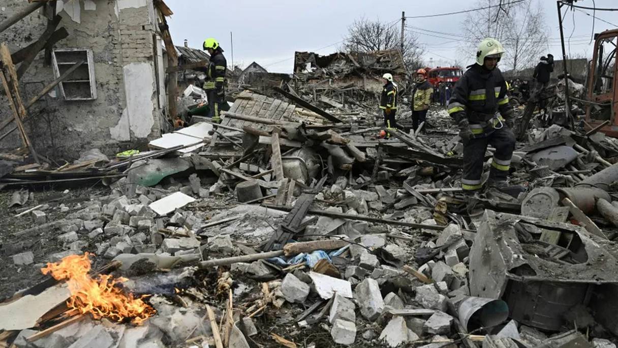Des pompiers dans les décombres de maisons bombardées de la banlieue de Kiev, le 29 décembre 2022.
