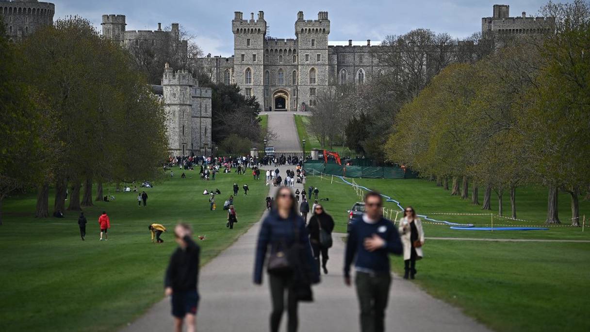 Des personnes se promènent dans le grand parc du château de Windsor, à l'ouest de Londres, le 9 avril 2021, à la suite de l'annonce de la mort du prince Philip, duc d'Edimbourg, qui était âgé de 99 ans.
