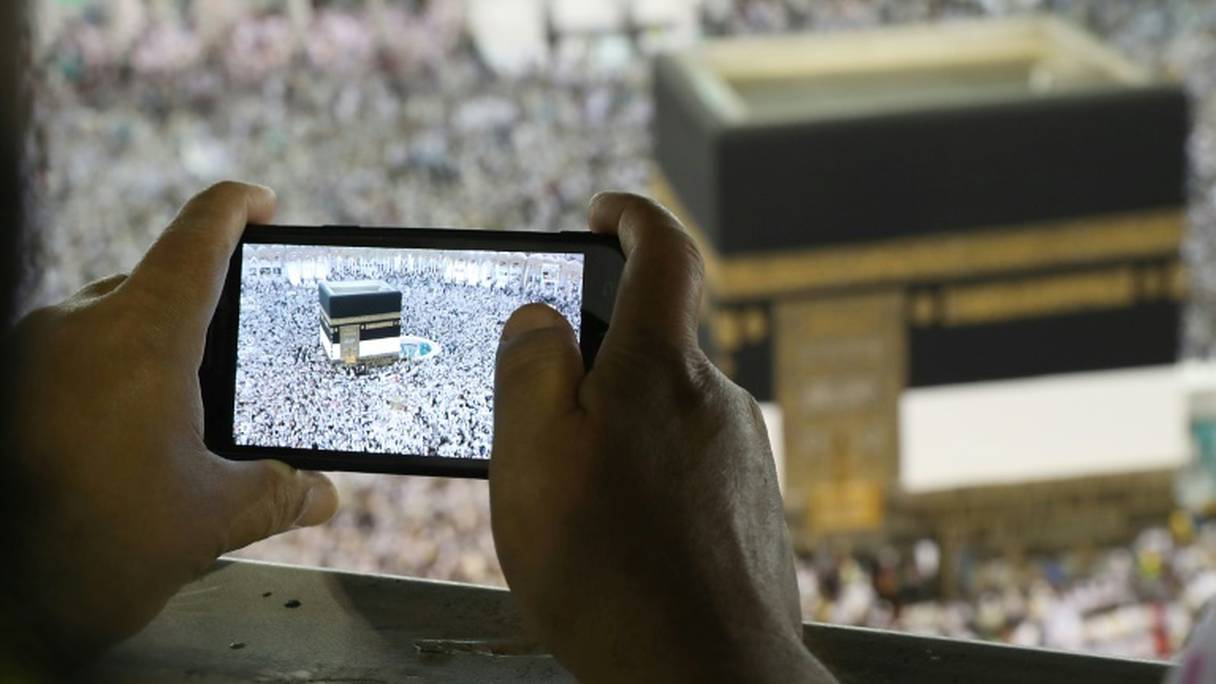Un homme prend une photo de la Kaaba, au centre de la Grande mosquée de La Mecque le 15 août 2018 à l'occasion du grand pèlerinage.
