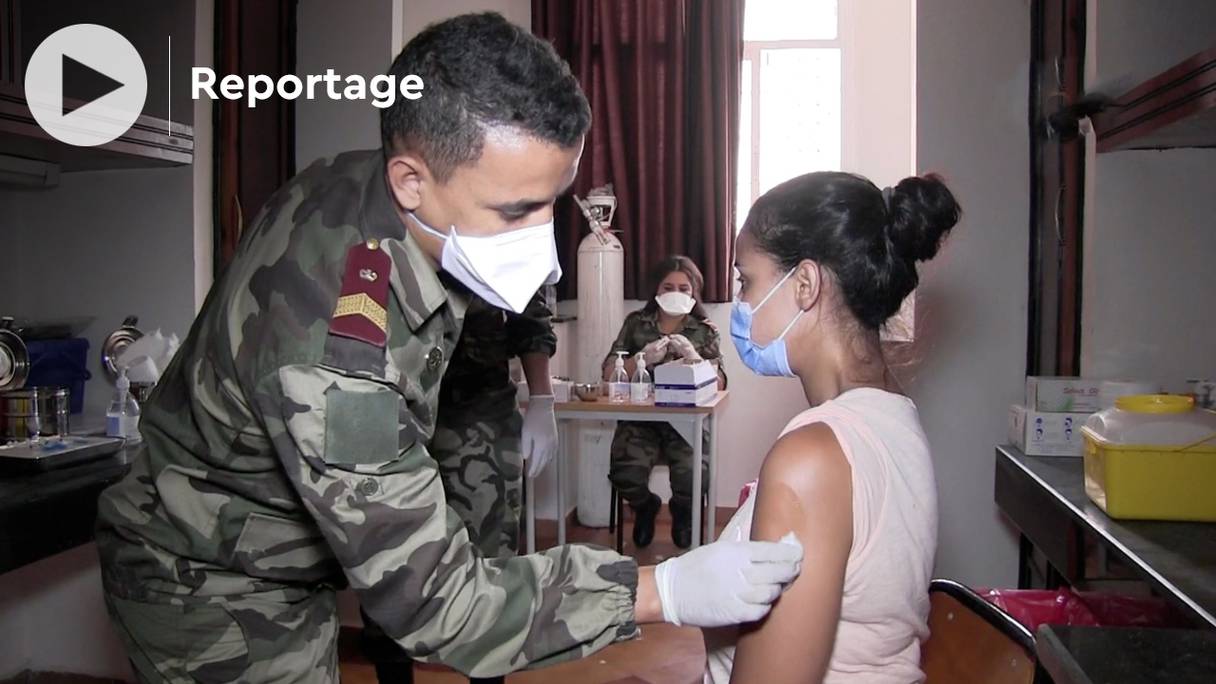 Une personne reçoit une injection d'un vaccin anti-Covid-19 d'un soldat, professionnel de la santé, issu des équipes médicales des Forces Armées Royales, au campus universitaire de la ville d’Agadir, le 28 juillet 2021. 
