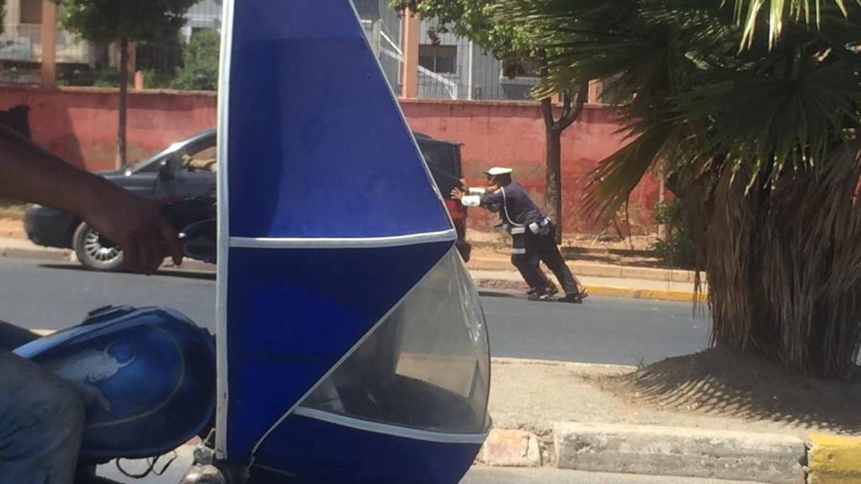 Un agent de police en charge de la régulation de la circulation aide un automobiliste dont la voiture est tombée en panne, le jeudi 23 juillet 2020 à Casablanca. 
