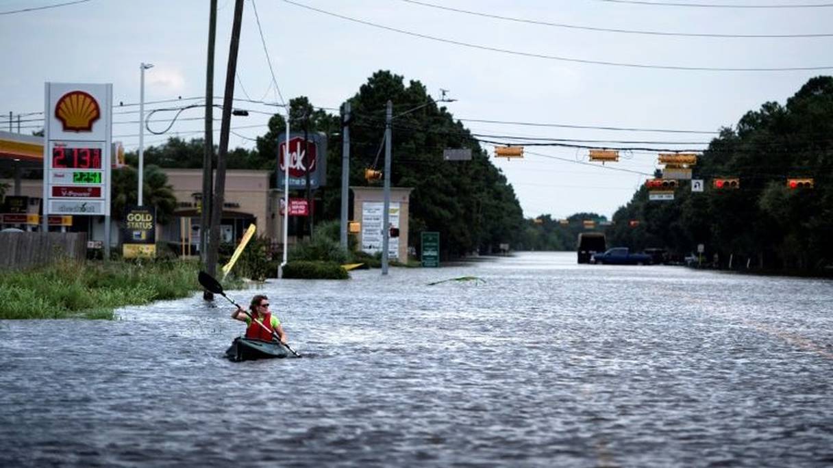 Une femme pagaie dans une rue envahie par les eaux à Houston, au Texas, après le passage de l'ouragan Harvey le 30 août 2017.
