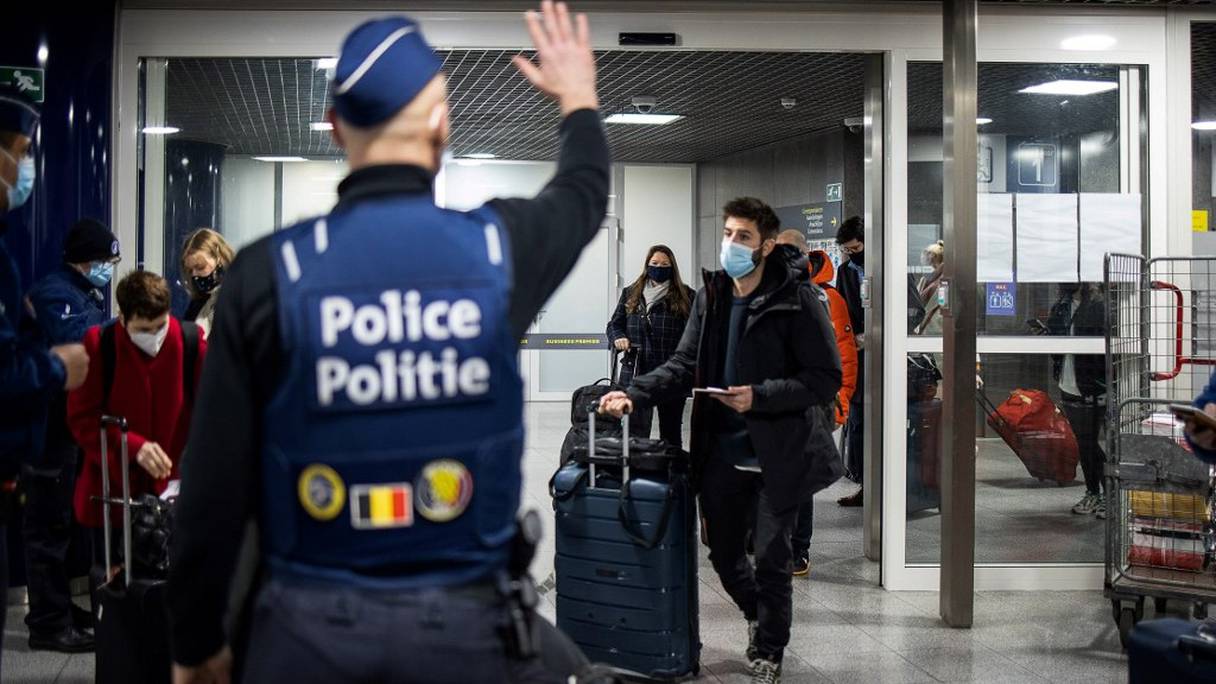 Des policiers belges contrôlent des voyageurs à leur arrivée à la gare de Bruxelles-Midi, le 15 janvier 2021, à Bruxelles. 
