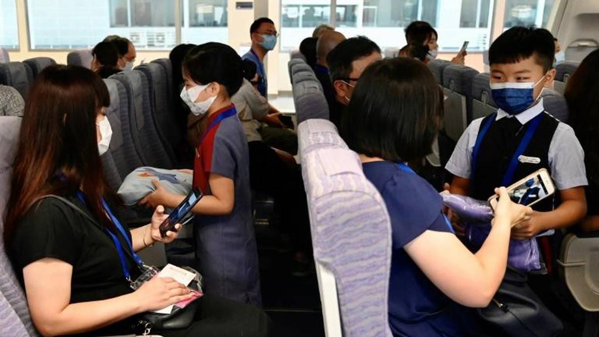 Des enfants et leurs parents jouent le rôle du personnel de cabine et de passagers, au siège de China Airlines, à Taoyuan (Taïwan), le 8 août 2020.
