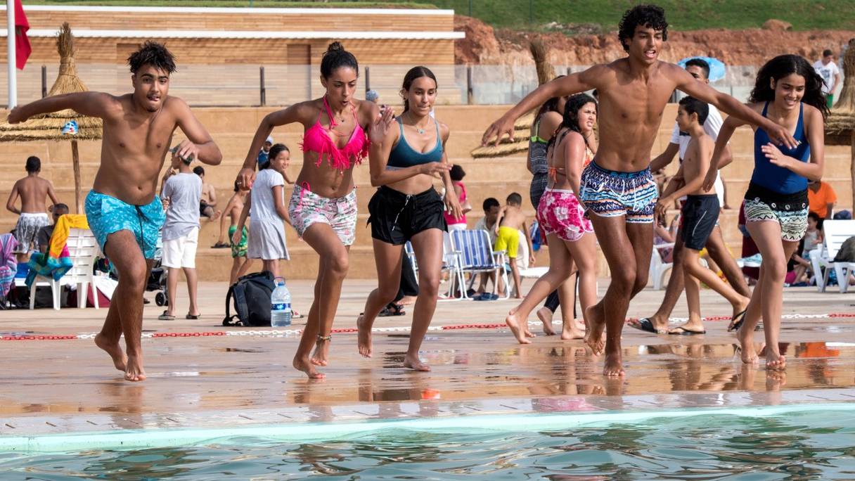 Par temps chaud, des jeunes se préparent à se jeter à l'eau dans la nouvelle piscine publique de la capitale, Rabat, le 7 août 2019.
