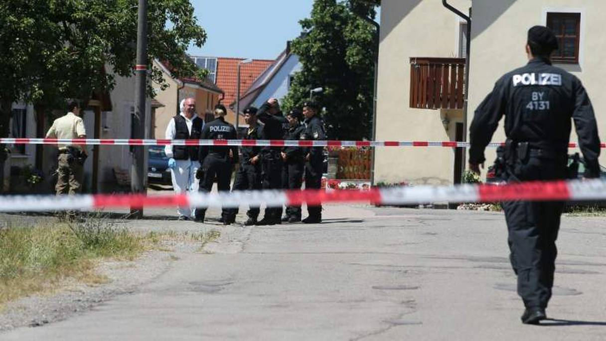 Des policiers devant la scène du crime près d'Ansbach en Bavière (Allemagne), le 10 juillet 2015.
