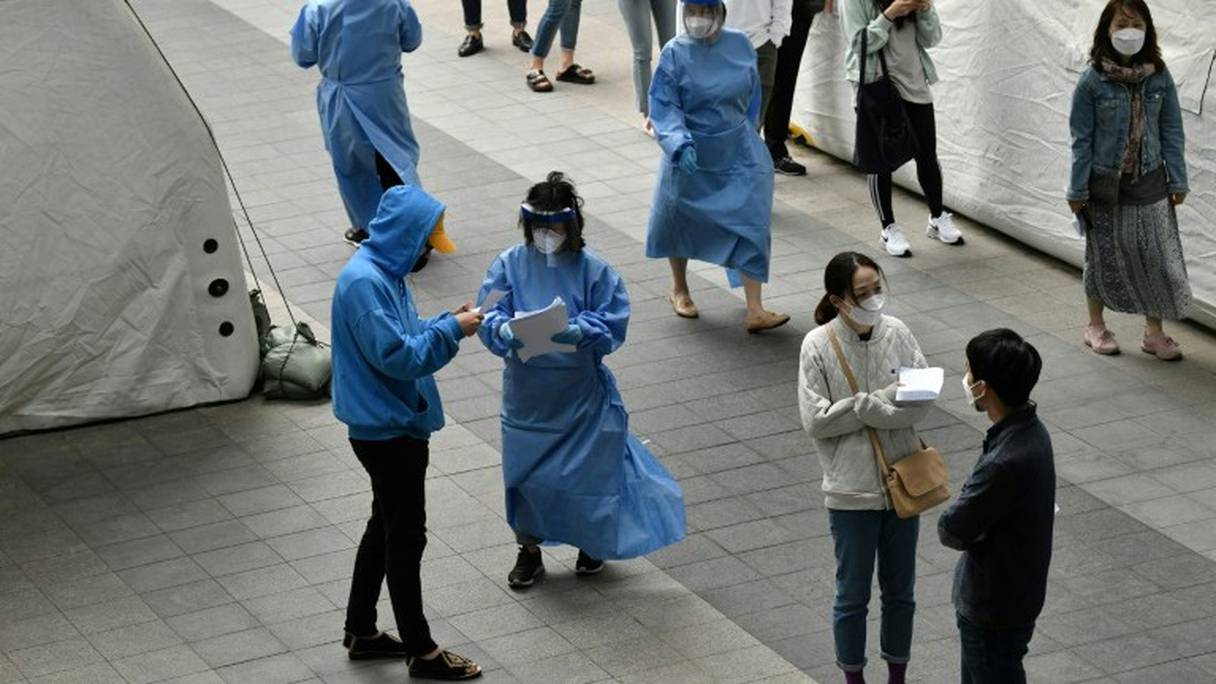 Du personnel médical guide les visiteurs d'un centre de tests du Covid-19 à Séoul, le 12 mai 2020.
