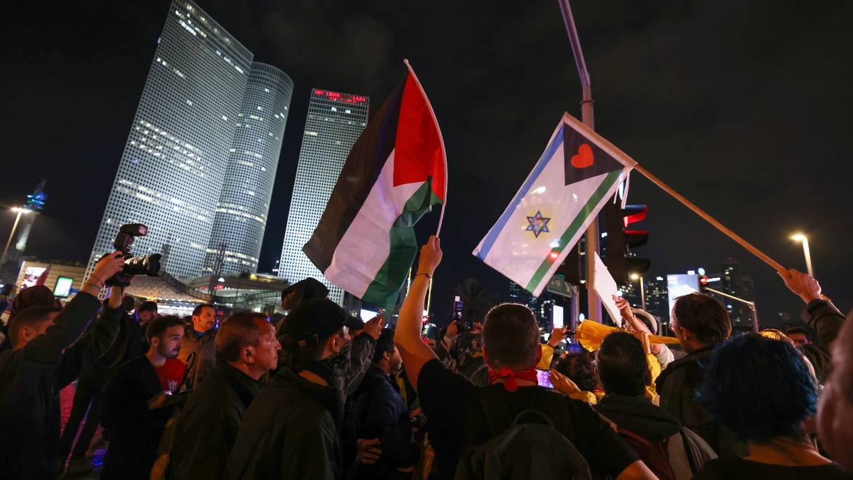 Des manifestants israéliens de gauche soulevant des drapeaux palestinien et israélien lors d'un rassemblement contre le nouveau gouvernement d'extrême droite du Premier ministre Benjamin Netanyahu, à Tel-Aviv le 14 janvier 2023.
