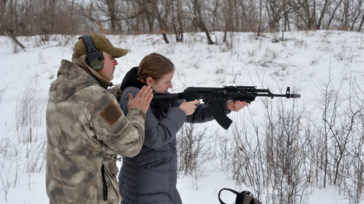 Un instructeur apprend à des civils à tirer avec des fusils AK-47 et des fusils à pompe lors d'un entraînement au tir à l'extérieur de la ville de Kharkiv, en Ukraine, le 6 février 2022.
