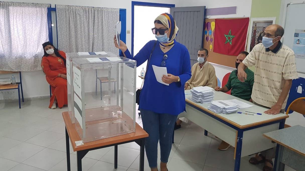 Une électrice glisse son bulletin de vote dans l'urne et s'acquitte de son devoir électoral, lors des scrutins législatifs, régionaux et municipaux du 8 septembre 2021, à l'école Abderrahmane Anegay, dans le centre-ville de Tanger.
