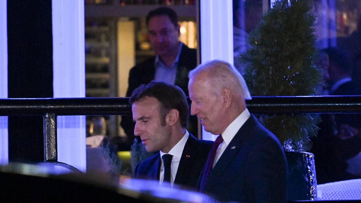 Le président français Emmanuel Macron s'entretient avec le président américain Joe Biden alors qu'ils quittent le restaurant Fiola Mare, après un dîner privé à Washington, le 30 novembre 2022.
