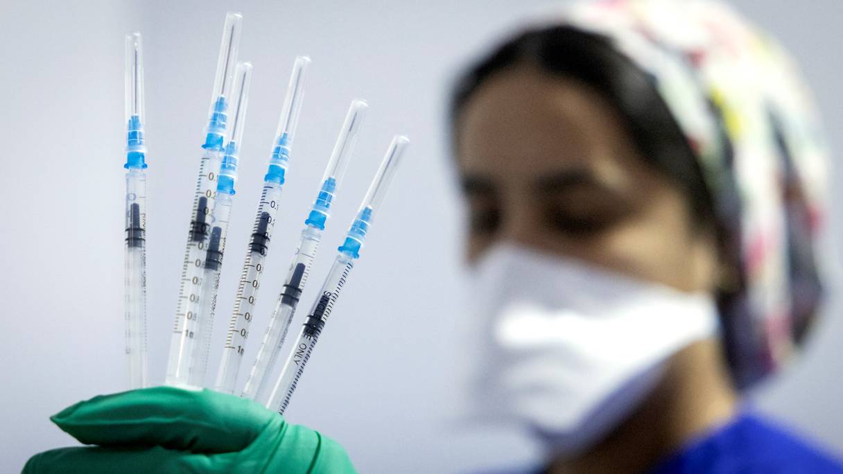 Une soignante porte dans sa main gantée des seringues contenant le sérum du vaccin Pfizer-BioNTech dans un centre de vaccination anti-Covid-19, dans la ville de Salé, le 5 octobre 2021.
