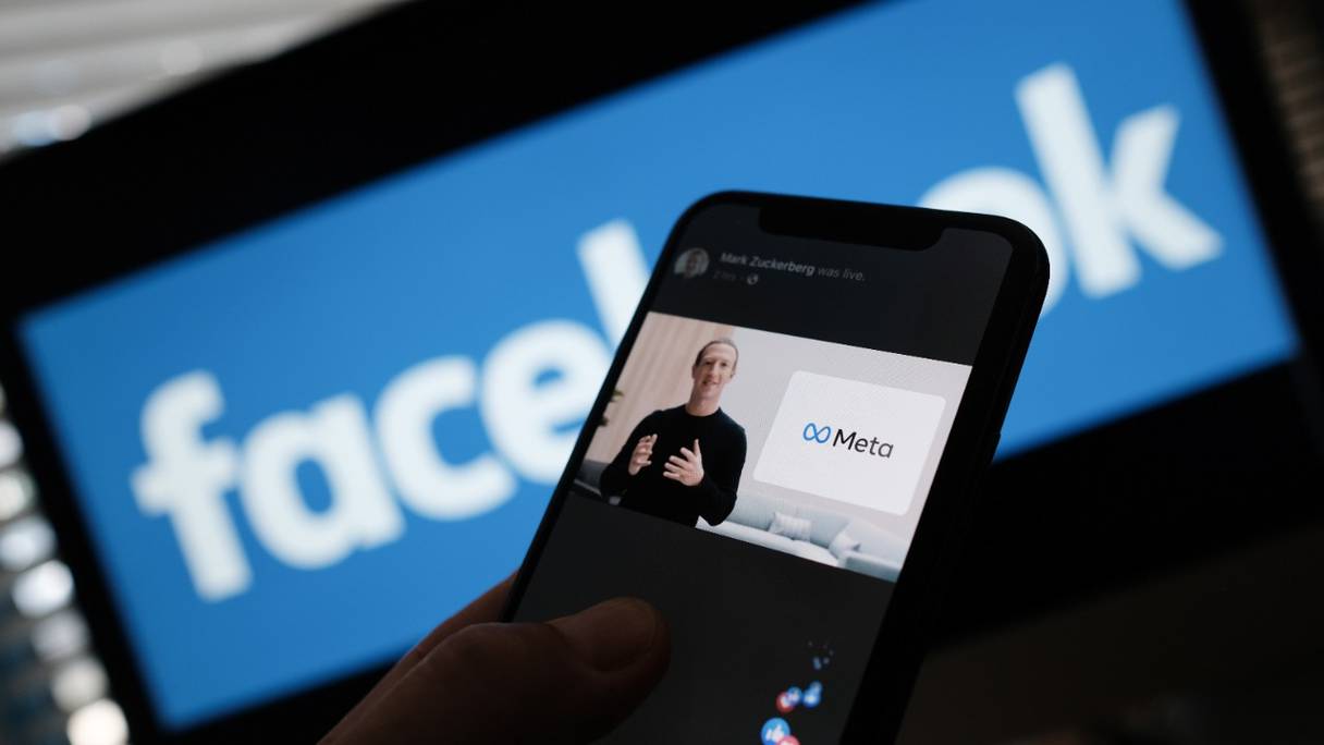 Quelqu'un regarde sur un smartphone le PDG de Facebook, Mark Zuckerberg, dévoiler le logo META, le 28 octobre 2021.
