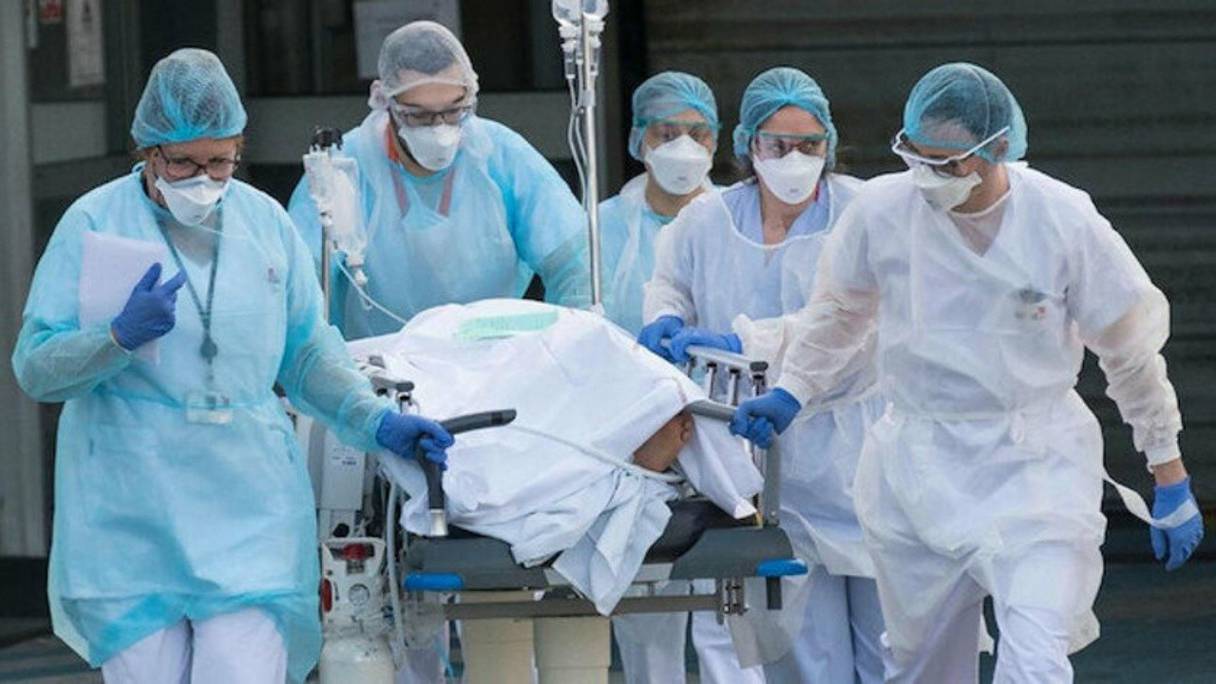 Une équipe médicale transfère un malade atteint par le Covid-19 dans un service d'urgence. 
