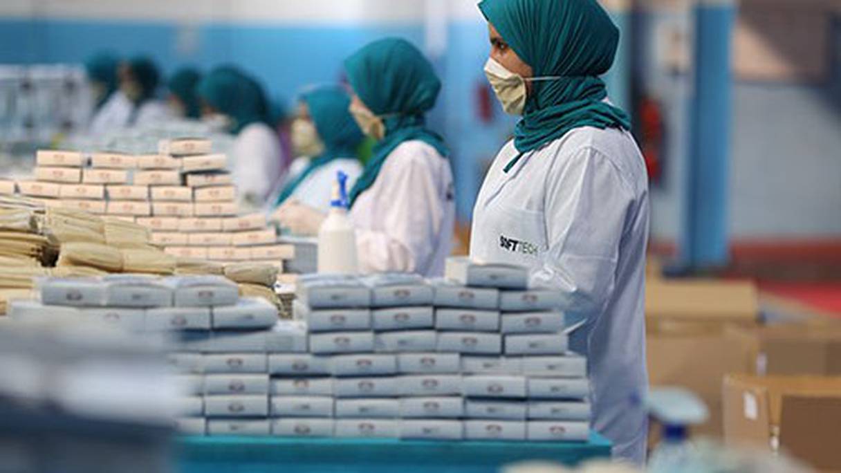 Des ouvrières travaillent à l'étape finale du conditionnement, dans une usine de masques sanitaires marocaine. 
