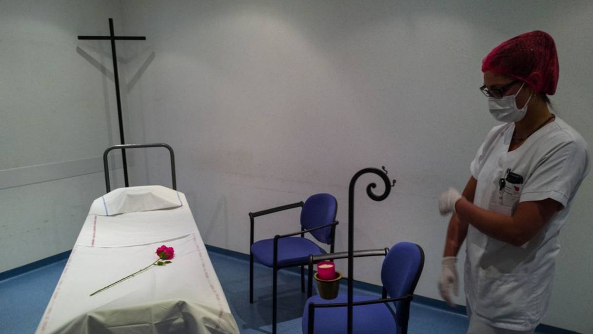 Un agent de la morgue de l'hôpital Emile Muller à Mulhouse, dans l'est de la France, a déposé une fleur en plastique sur une civière, une manière symbolique de présenter le décès des suites du Covid-19 d'un proche à sa famille, le 22 avril 2020 (archives).
