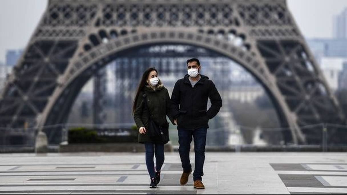 Un couple, au pied de la tour Eiffel, mercredi 1er avril 2020, à Paris. 
