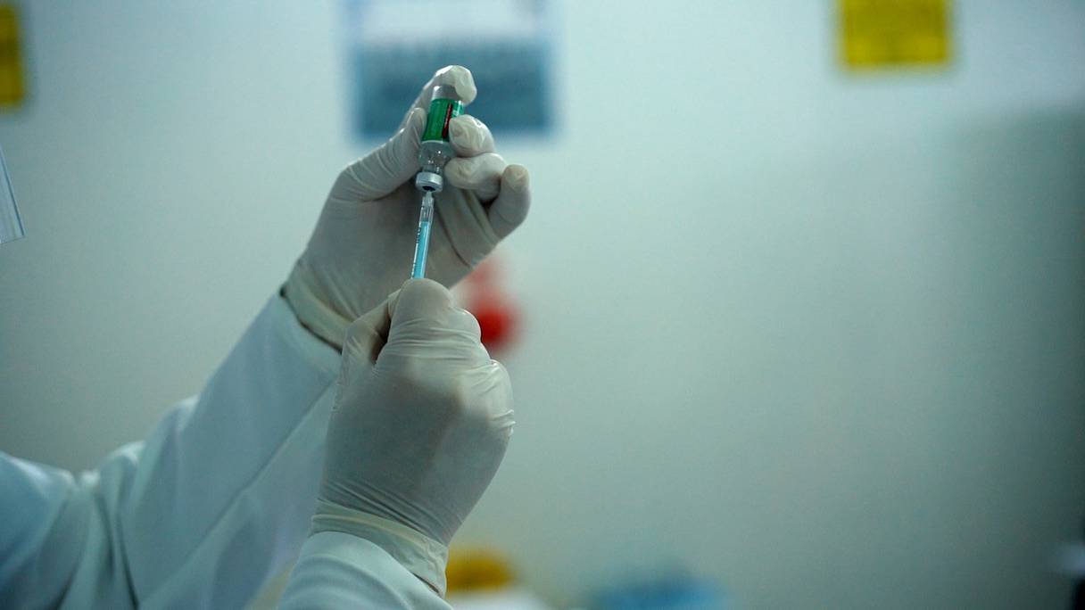 Un professionnel de la santé se prépare à injecter une dose d'un vaccin anti-Covid-19. 
