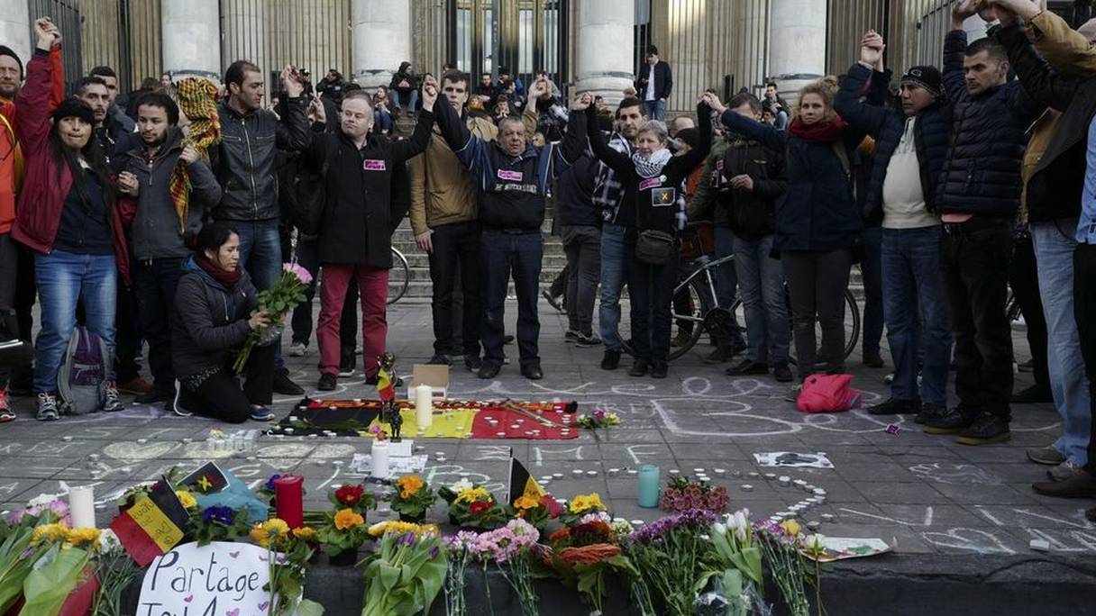 Des personnes se réunissent à Bruxelles pour rendre hommage aux victimes des attentats. 
