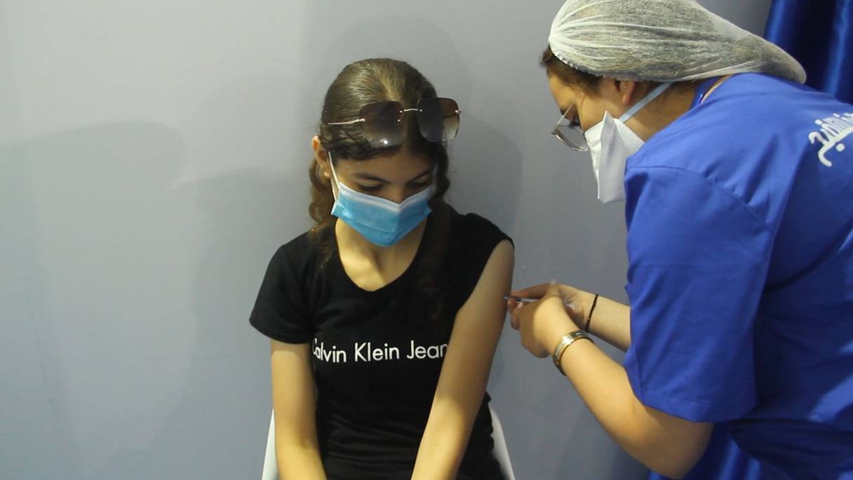 Une professionnelle de la santé injecte une dose d'un vaccin anti-Covid-19 à une adolescente, le 24 août 2021, au vaccinodrome de Salé, opérationnel depuis peu.
