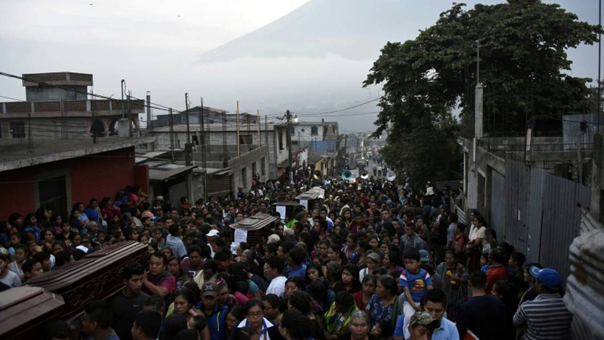 Les cercueils de sept des victimes de l'éruption du Volcan de Feu défilent dans une rue d'Alorenango, au Guatemala, le 4 juin 2018.

