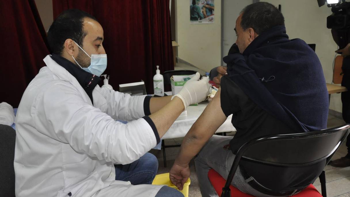 Un soignant administre la troisième dose d'un vaccin anti-Covid-19 dans un centre de vaccination à Azilal, le 24 janvier 2022.
