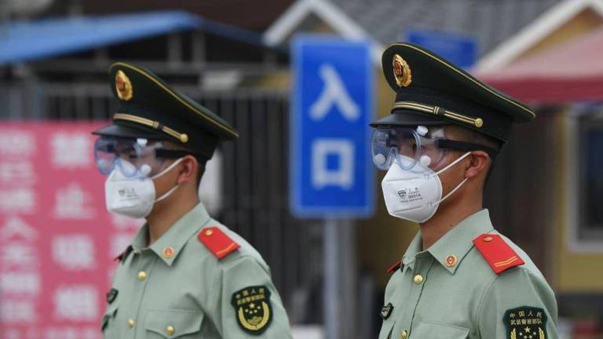 Des policiers chinois gardent l'entrée du marché Xinfadi, à Pékin, le 13 juin 2020.
