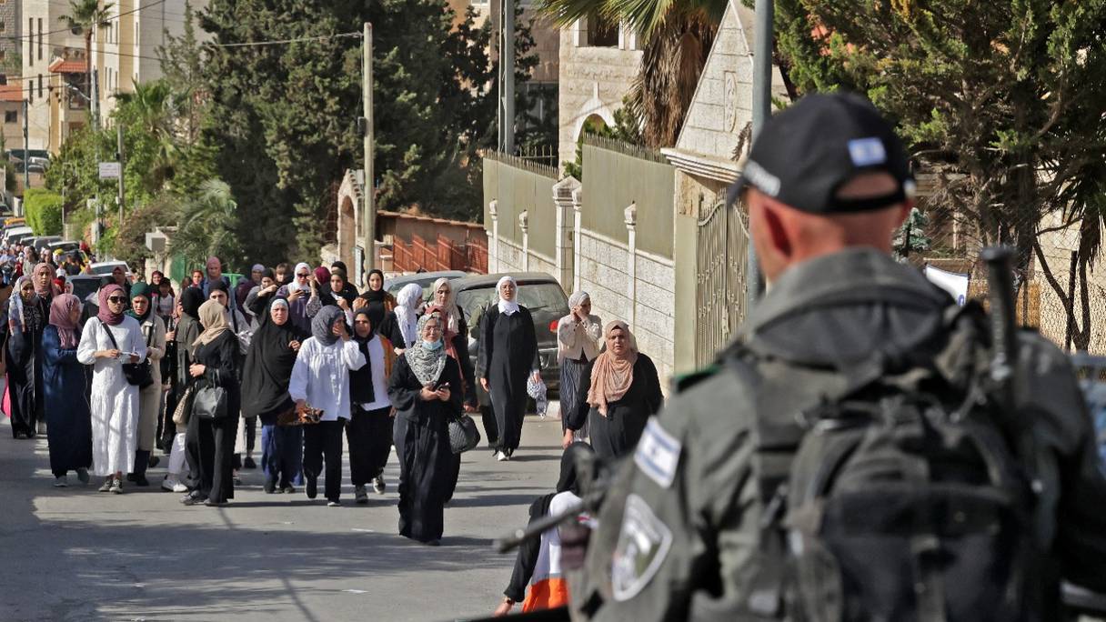 Des soldats israéliens surveillent des Palestiniens qui traversent un poste de contrôle pour rejoindre Jérusalem pour les dernières prières du vendredi du Ramadan à al-Aqsa, le 29 avril 2022, à Bethléem, en Cisjordanie occupée.
