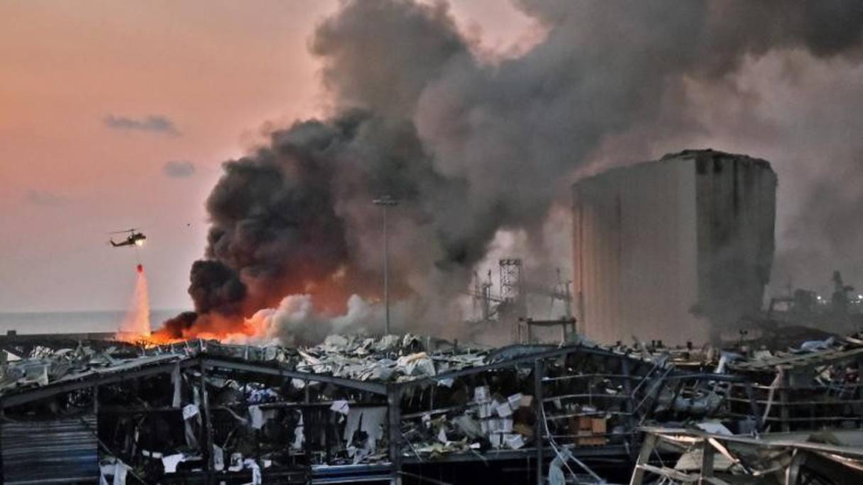 Un hélicoptère tente d'éteindre les flammes après l'explosion, le 4 août 2020 à Beyrouth, au Liban.
