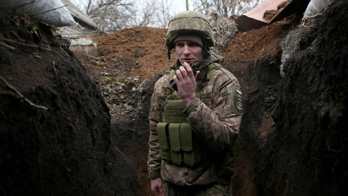 Un militaire des forces militaires ukrainiennes communique via un talkie-walkie, dans la première ligne du front qui oppose ce pays avec les séparatistes soutenus par la Russie, près de Novolugansk, dans la région de Donetsk, le 17 février 2022.

