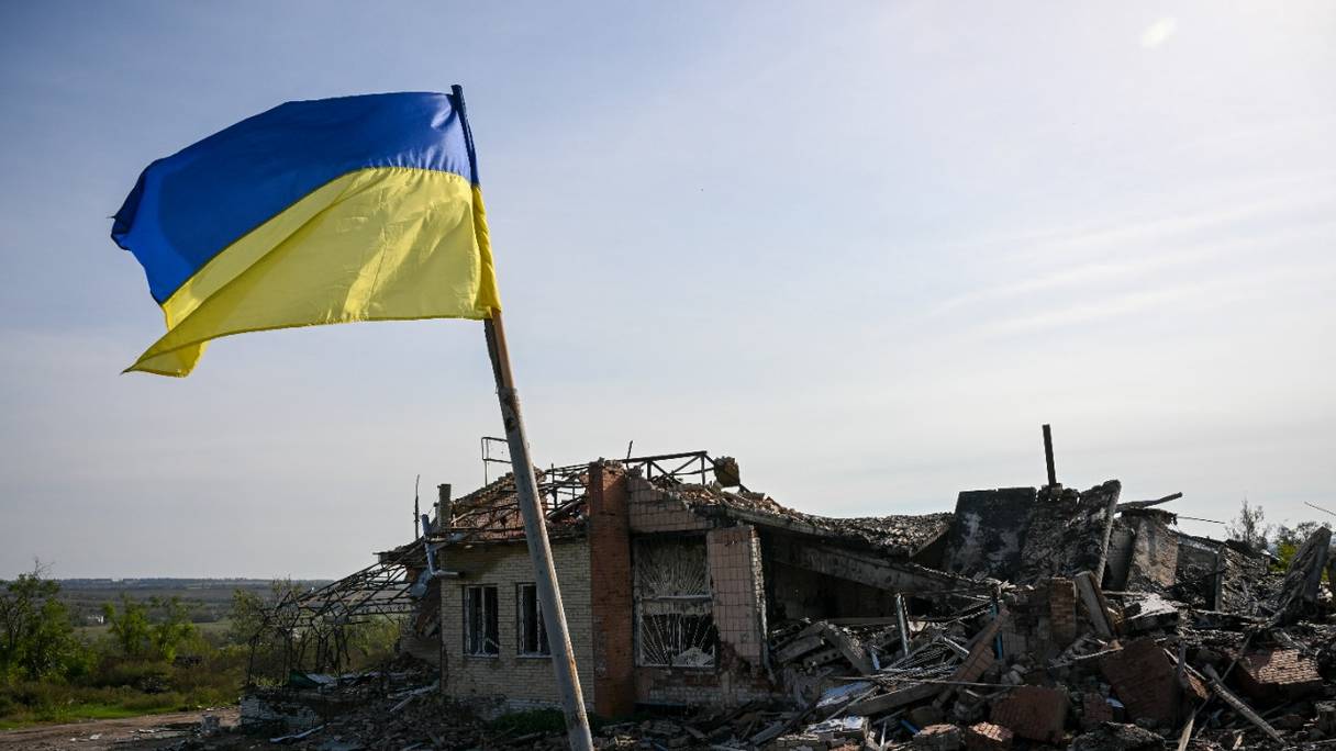 Le drapeau national ukrainien flotte devant une maison détruite près d'Izyum, dans l'est de l'Ukraine, le 1er octobre 2022, au cours de l'invasion russe du pays.

