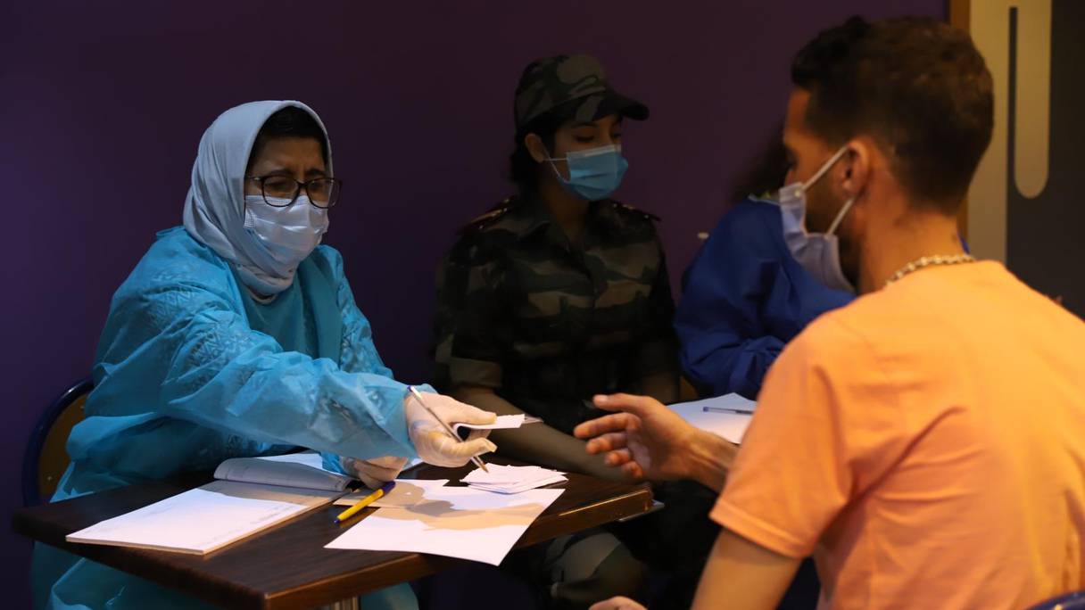 Une personne s'inscrit pour se faire vacciner contre le Covid-19, dans un centre de vaccination de Rabat, où les équipes médicales des Forces Armées Royales (FAR) travaillent aux côtés des équipes médicales du ministère de la Santé, le 29 juillet 2021. 
