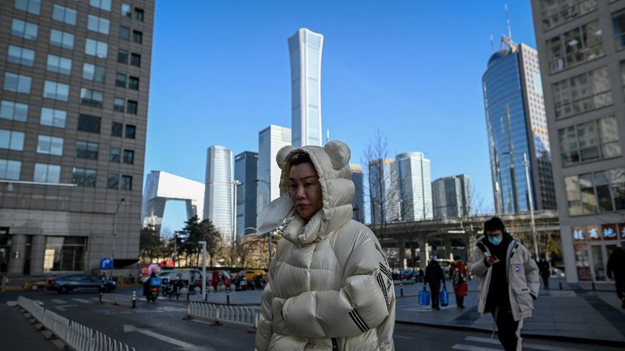 Des piétons traversent une avenue, dans le centre d'affaires de Pékin, le 18 janvier 2021. 
	 
