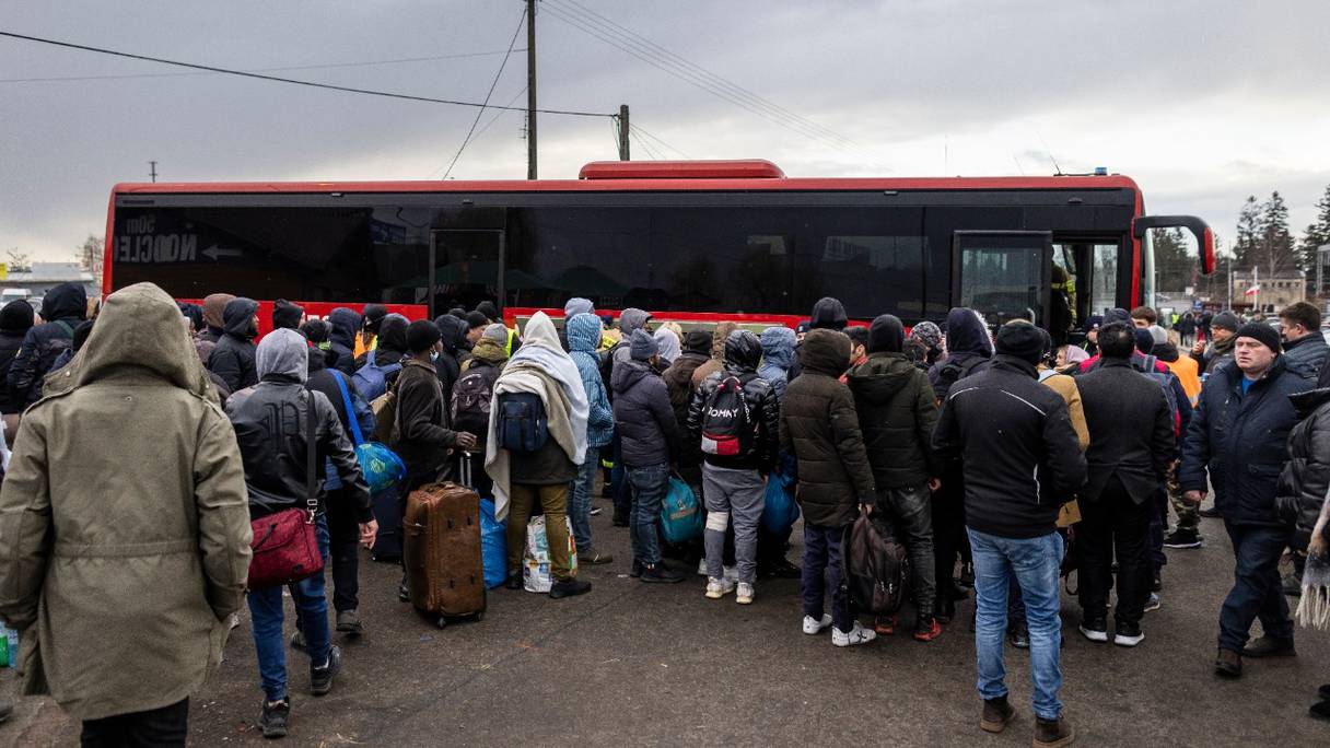 Des réfugiés de différentes nationalités, pour la plupart des étudiants dans les universités ukrainiennes, se rassemblent pour prendre un bus au poste-frontière de Medyka, dans l'est de la Pologne, le 27 février 2022.
