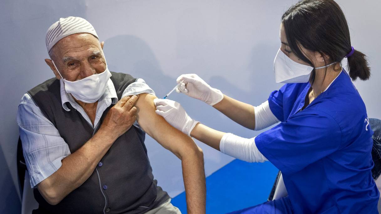 Un agent de santé marocain administre une dose du vaccin Pfizer-BioNTech contre le Covid-19 dans un centre de vaccination, dans la ville de Salé, le 5 octobre 2021.
