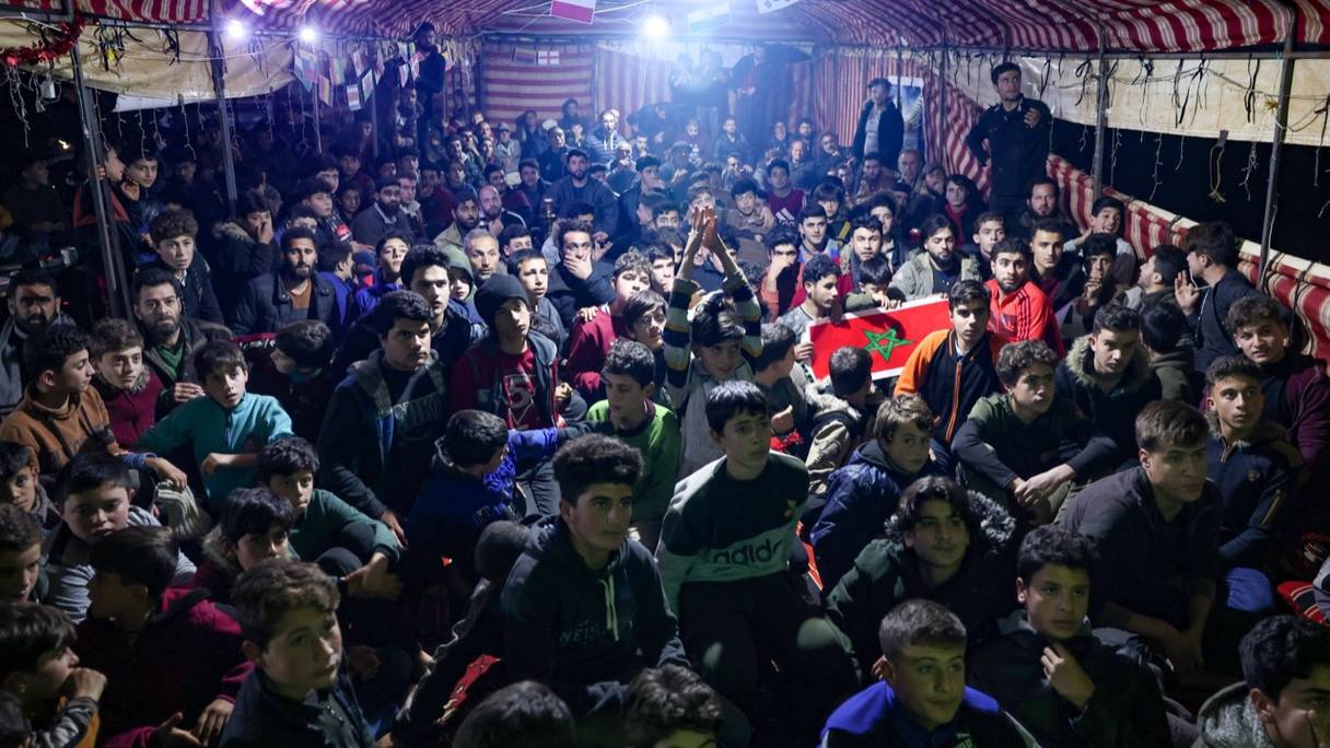 Des réfugiés syriens suivent le match Maroc-Portugal dans un espace aménagé par des travailleurs humanitaires dans la région d'Idlib.
