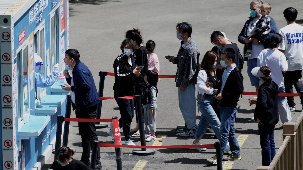 Un agent de santé teste un homme, afin de détecter le Covid-19, à Pékin, le 26 avril 2022. Des tests de masse pour presque tous les 21 millions d'habitants de Pékin ont été lancés et les craintes d'un confinement, comme à Shanghai, grandissent.
