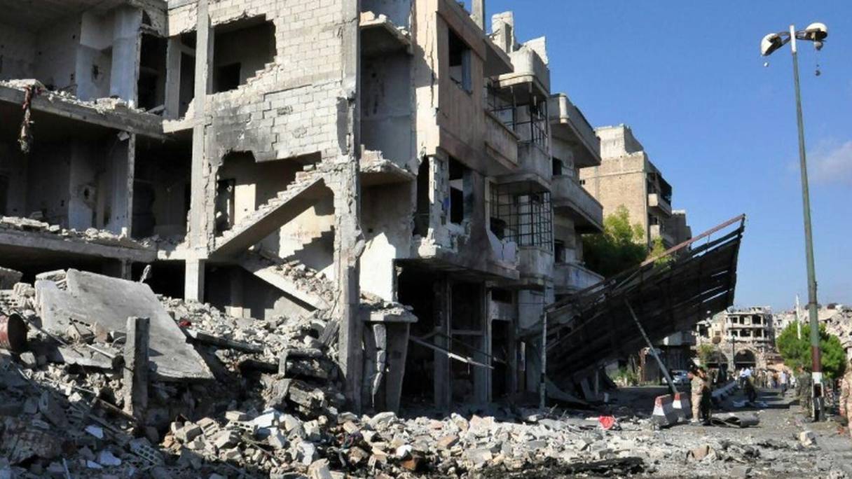 Photo fournie par l'agence officielle Sana montrant des soldats syriens inspectant les lieux d'un attentat à la bombe à Homs, le 5 septembre 2016.

