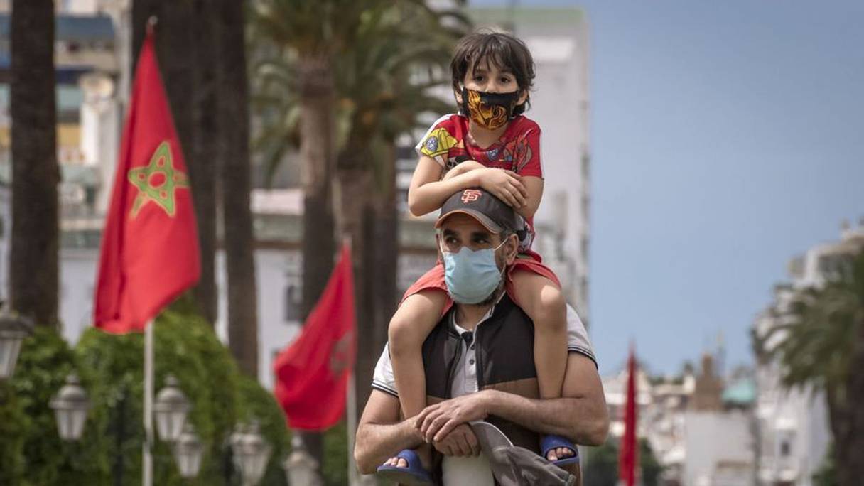 Un homme et son fils masqués se promènent dans le centre-ville de Rabat, le 16 juin 2020.
