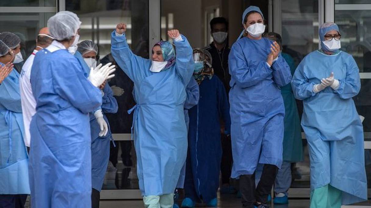 Des personnels soignants applaudissent la sortie de patients guéris du Covid-19 le 12 avril 2020, à Rabat. 
