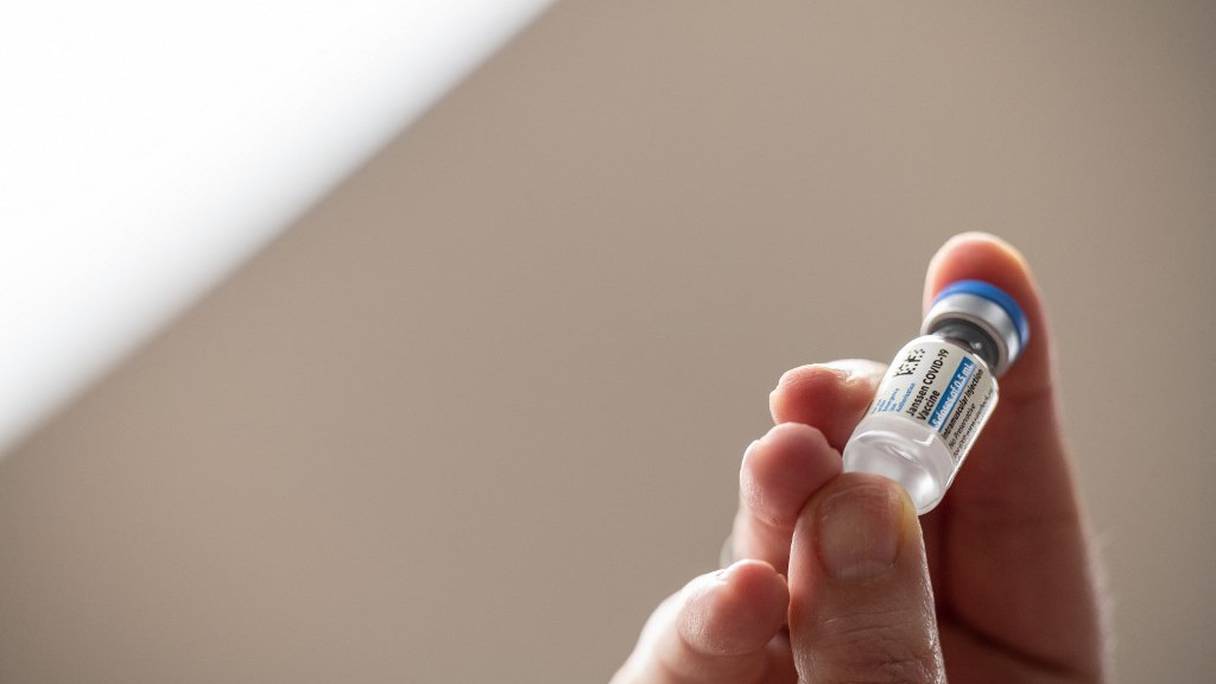Une employée du ministère américain de la Santé tient le premier flacon du vaccin Janssen COVID-19, développé par le laboratoire Johnson & Johnson, au siège social de Louisville Metro Health and Wellness, le 4 mars 2021, à Louisville, dans le Kentucky. 

