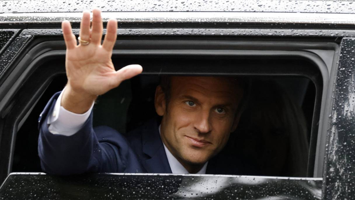 Le président français Emmanuel Macron salue la foule après avoir voté, lors du second tour des élections législatives dans un bureau de vote du Touquet, dans le nord de la France, le 19 juin 2022.
