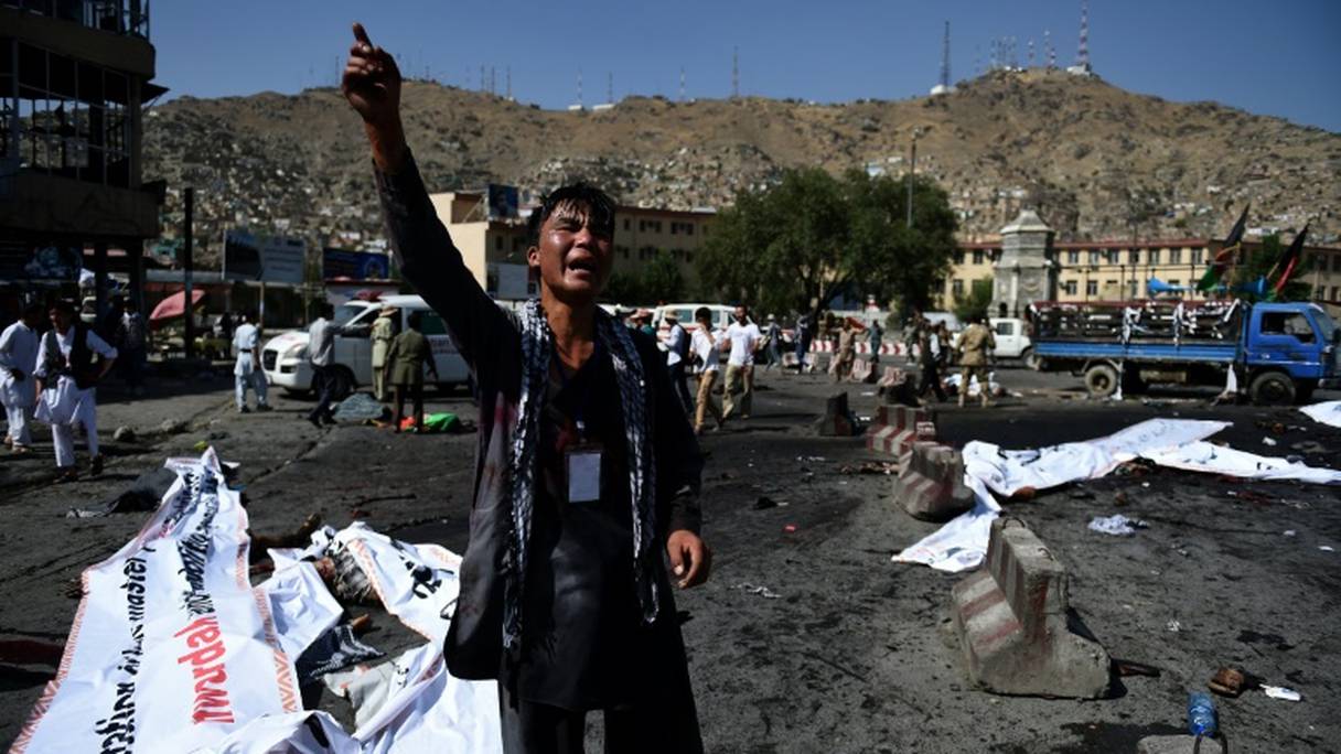 Un Afghan hurle sa colère sur la scène d'un attentat suicide à Kaboul, le 23 juillet 2016.
