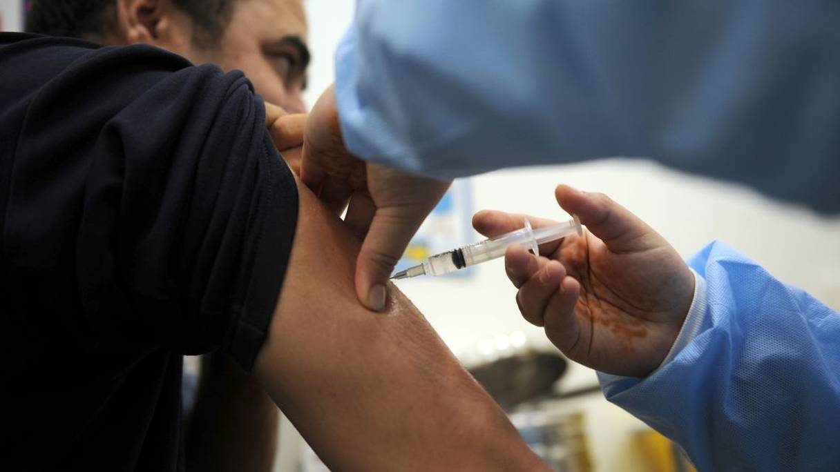 Injection d'un vaccin par un praticien de santé sur le bras d'un patient. 
