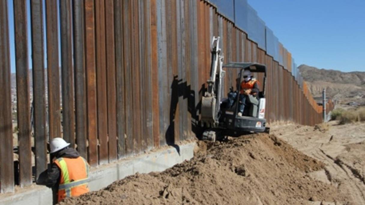 Des ouvriers travaillent le long de la frontière entre le Mexique et les Etats-Unis. 
